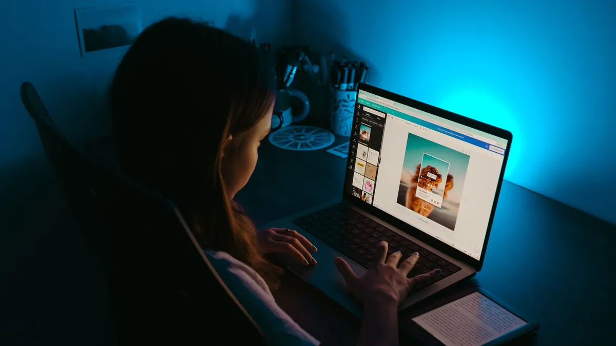 Laptop open on a kitchen table in the evening for an online loan application