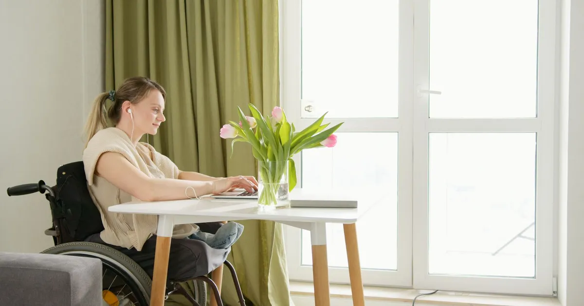Ontario resident in a wheelchair applying for instant loans ODSP recipients qualify for on a laptop at home