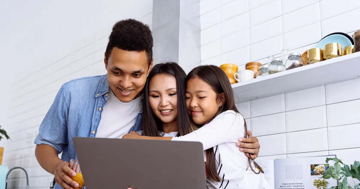 Family at a kitchen table applying for instant loans on benefits from a laptop